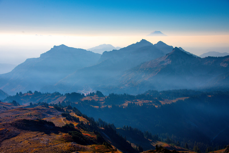 Multiple mountain ridgelines receding into atmospheric haze at golden hour in the Cascades